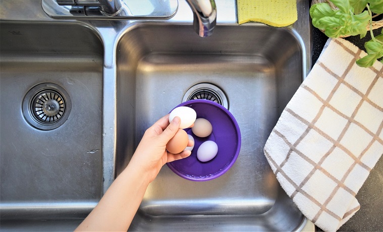 Eggs in a bowl in a sink during washing process